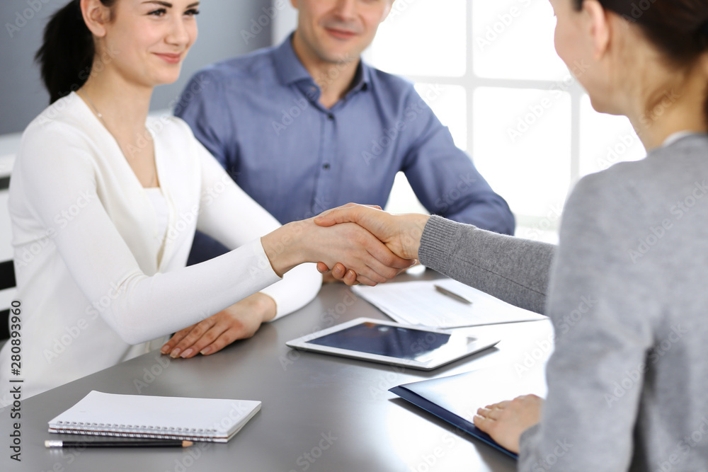Group of business people shaking hands after discussing questions at meeting in modern office. Handshake close-up. Teamwork, partnership and agreement in business concept Group of business people shaking hands after discussing questions at meeting in modern office. Handshake close-up. Teamwork, partnership and agreement in business concept