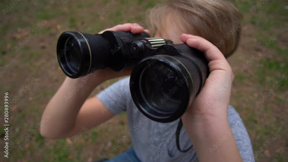 Closeup portrait of cute curious kid exploring nature using old vintage binoculars. Wide angle handheld video shoot in 4k. Closeup portrait of cute curious kid exploring nature using old vintage binoculars. Wide angle handheld video shoot in 4k.
