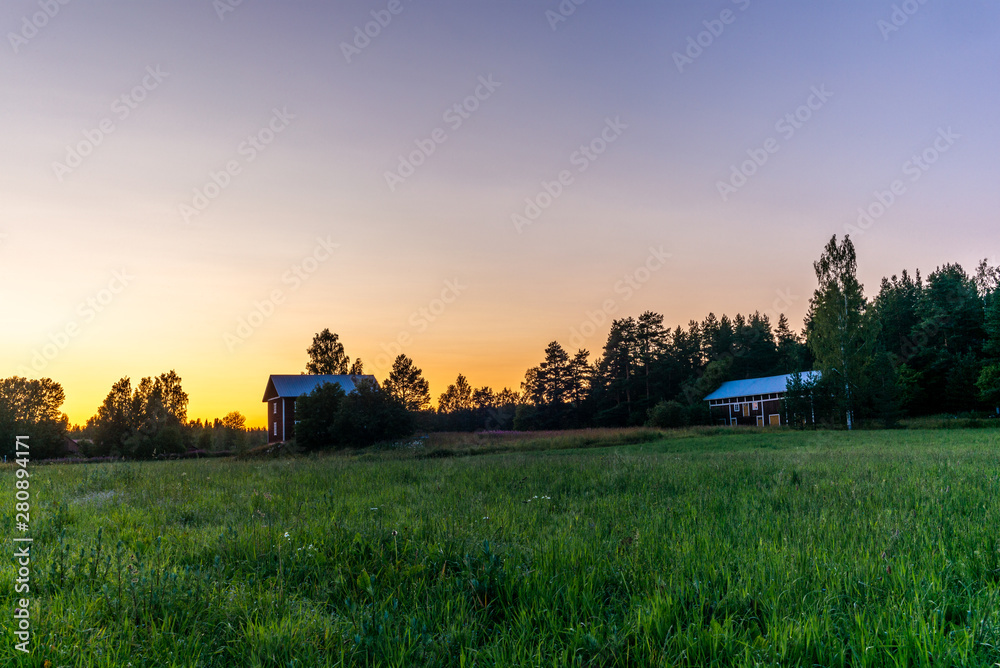 Fototapeta premium Traditional red nordic wooden shed in Finland during a colorful sunset - 2