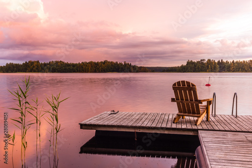 Tela Wooden lounge chairs at Sunset on a pier on the shores of the calm Saimaa lake i