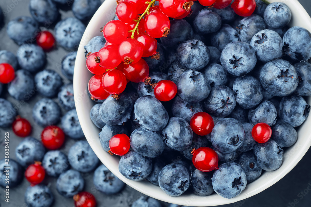 Fresh selected blueberries and red currant in bowl, close-up