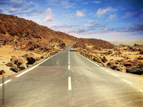 Asphalt highway between stones under a dramatoc sky with clouds photo