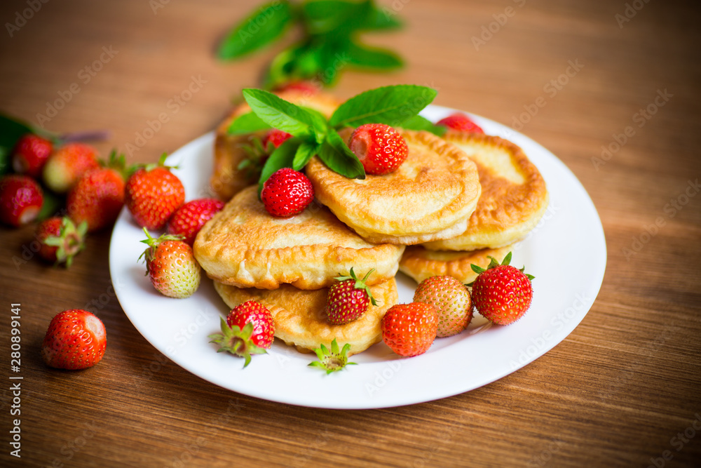 fried sweet pancakes with ripe strawberries in a plate fried sweet pancakes with ripe strawberries in a plate