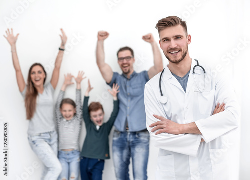 portrait of a family doctor on the background of his happy patients