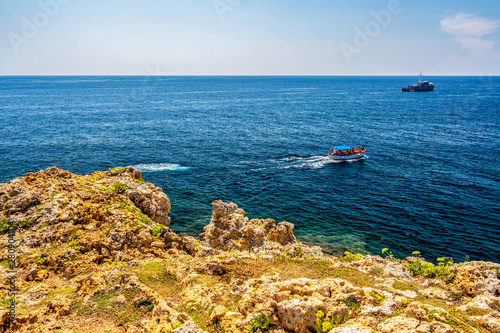 Punta Ristola coastline with a tourist boat near Santa Maria di Leuca, Province of Lecce, Apulia, Italy