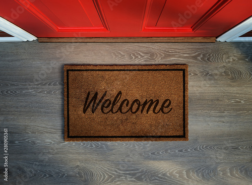 Overhead view of welcome mat outside inviting front door of house photo