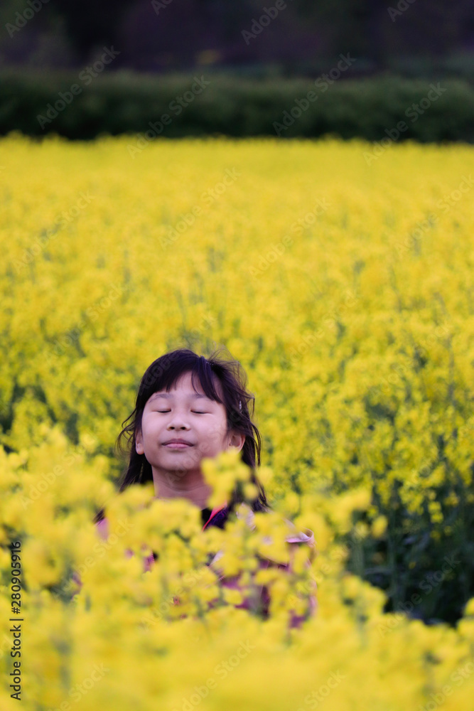 A girl feeling happy and admiring the beauty of canola field