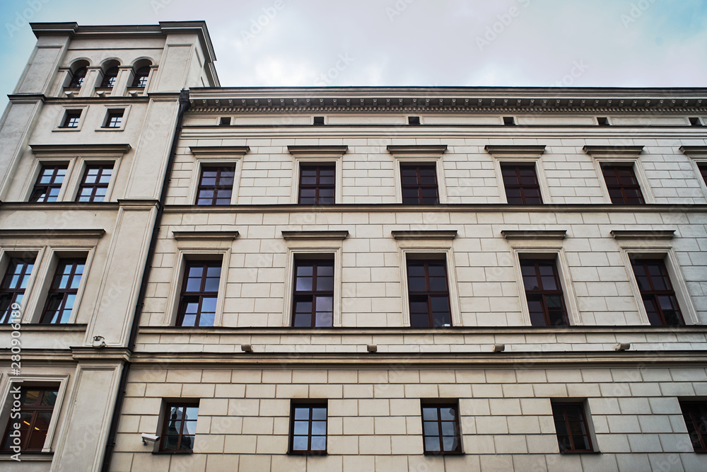 facade of a neoclassical building with a four-sided tower in the city of Poznan.