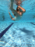 Young girl dives into a pool in a summer day. Underwater view 