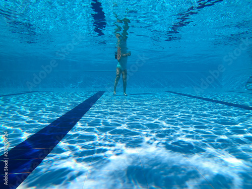 Young girl dives into a pool in a summer day. Underwater view  © nvphoto