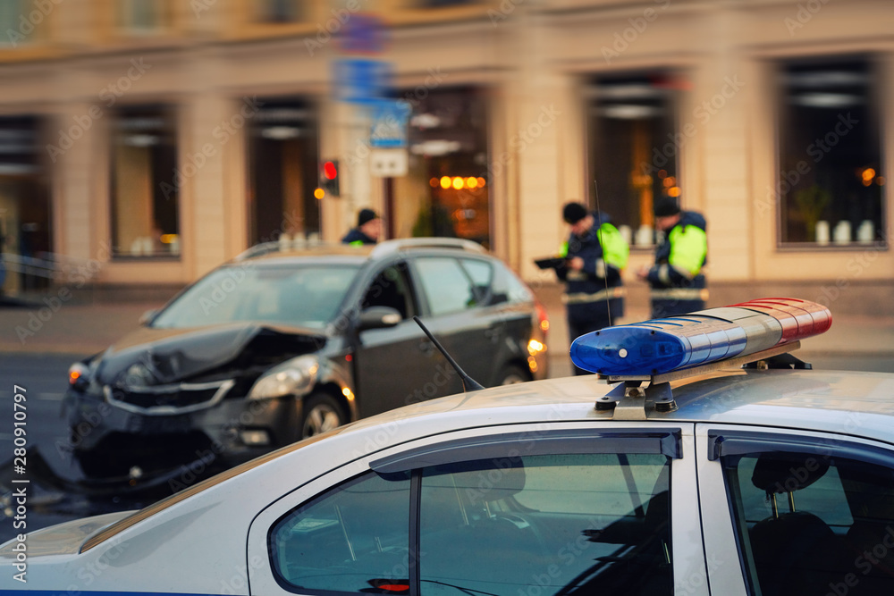Blue flashing lights and siren at police car. Police officer on background. Automobile collision on city highway. Investigating car accident, road crash Blue flashing lights and siren at police car. Police officer on background. Automobile collision on city highway. Investigating car accident, road crash
