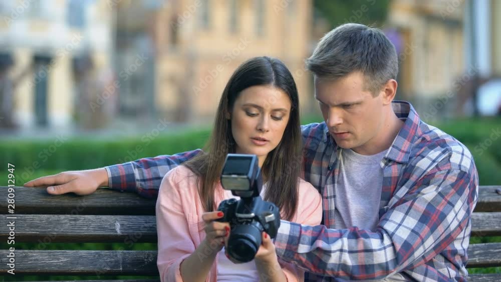 Male helping girlfriend to make photo with new professional camera, hobby