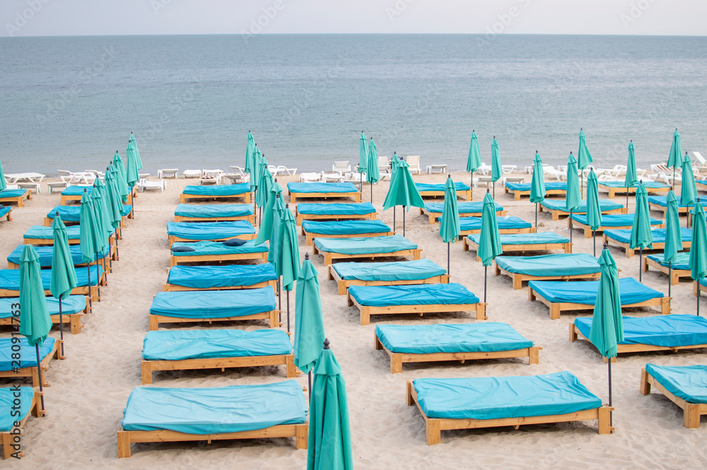 Obraz premium many empty beach beds near the sea, a beach without people, an abandoned resting place