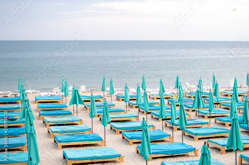 many empty beach beds near the sea  a beach without people  an abandoned resting place