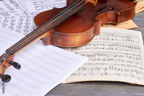 Sheets of musical symbols and violin. Viola on musical notes sheets. Musical instrument of orchestra.