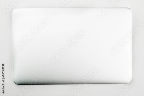 Closed laptop over white background. Silver laptop isolated on white. Modern portable technology concept.