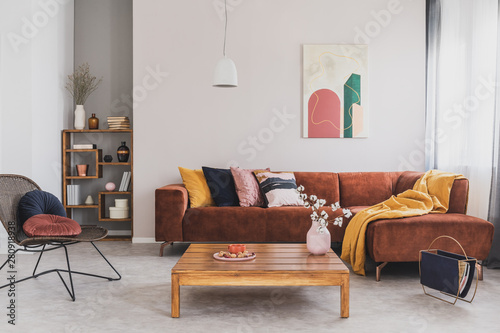 Φωτογραφία Flowers in vase on wooden coffee table in fashionable living room interior with