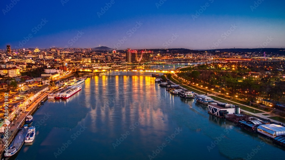 Belgrade on the river with boats and buildings at night with reflection and the night sky