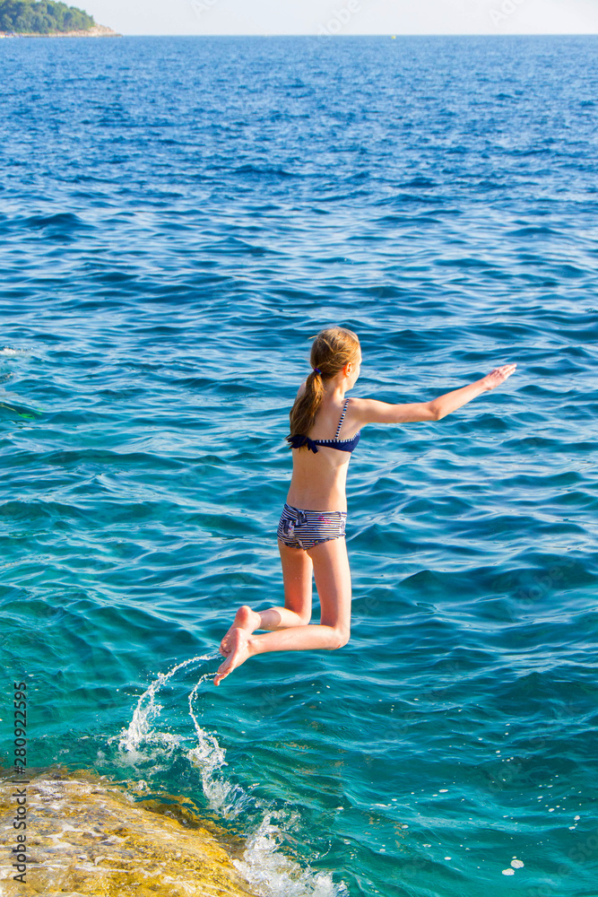 Young girl leaping into sea