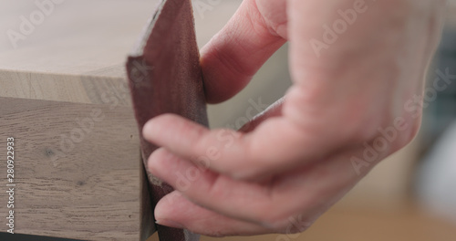 woodworker hand sanding black walnut drawer tray © GCapture