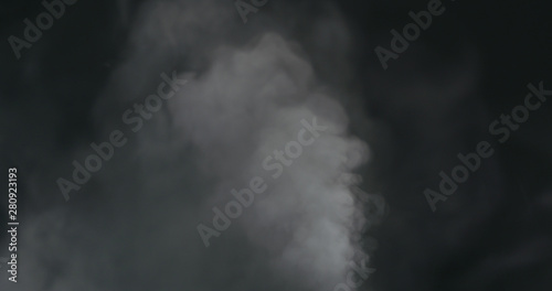 water vapor cloud comes from below over black background with motion blur