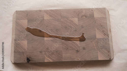 woodworker applying oil finish to walnut end grain wood board from above photo