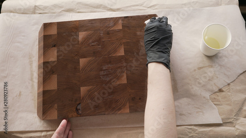 woodworker applying oil finish to walnut end grain wood board from above photo