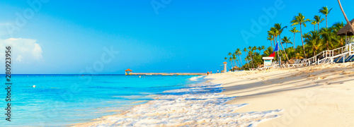 Beautiful beach with palm trees. Tropical paradise beach with white sand. Summer tropical landscape, panoramic view. Summer vacation travel holiday background concept. Caribbean beach. Palm beach