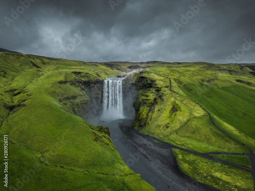 Skogafoss waterfall Iceland. Beautiful huge waterfall surrounded by green hills. Spring in Iceland.