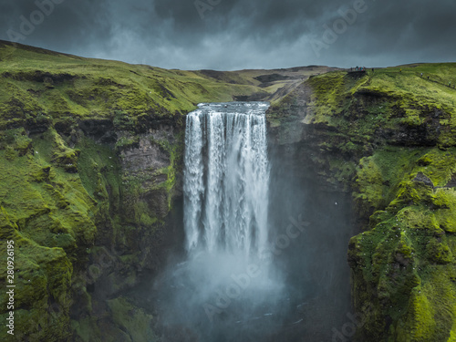 Skogafoss waterfall Iceland. Beautiful huge waterfall surrounded by green hills. Spring in Iceland.