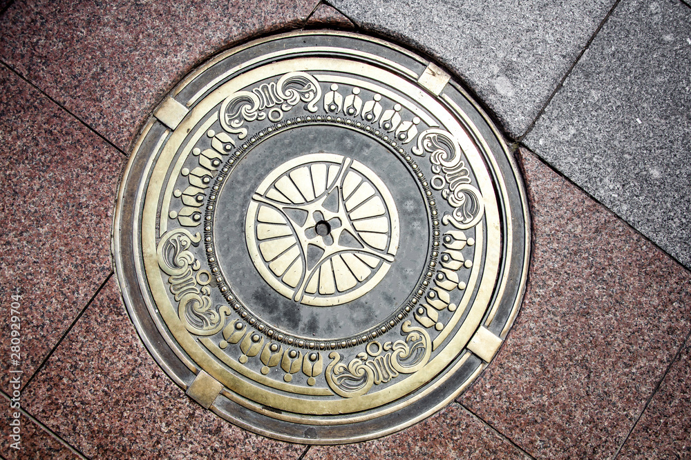 Exclusive manhole cover on the road. Beautiful design of the manhole cover.