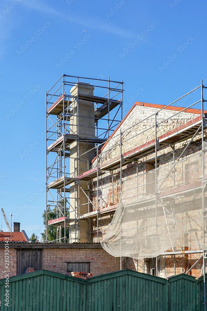 chimney repair during building renovation, scaffolding around the chimney