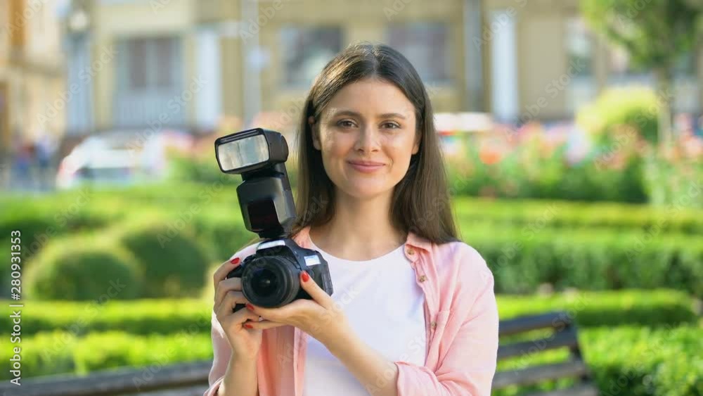 Female photographer taking photos with camera in park, lessons for beginners Female photographer taking photos with camera in park, lessons for beginners