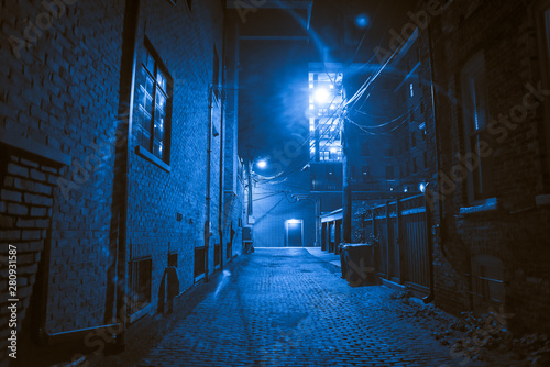 Dark and scary vintage cobblestone brick city alley at night in Chicago