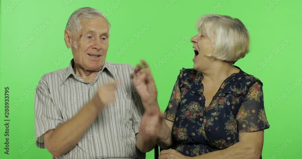 Senior aged man and woman sitting and talking together. Chroma key background Senior aged man and woman sitting and talking together. Chroma key background