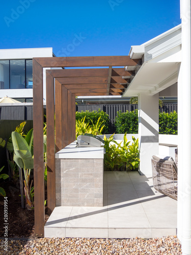 Modern wooden pergola and BBQ grill in outdoor garden