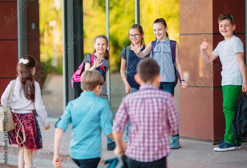 Fotografi Schoolmates go to school. Students greet each other.