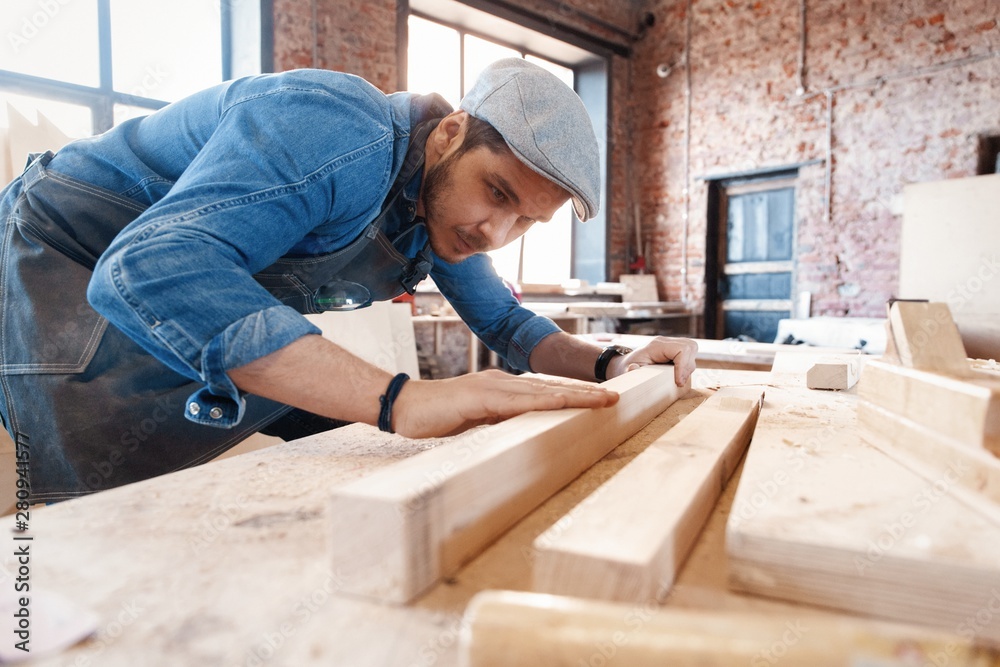 Successful handsome businessman with stylish cap work in carpentry Successful handsome businessman with stylish cap work in carpentry