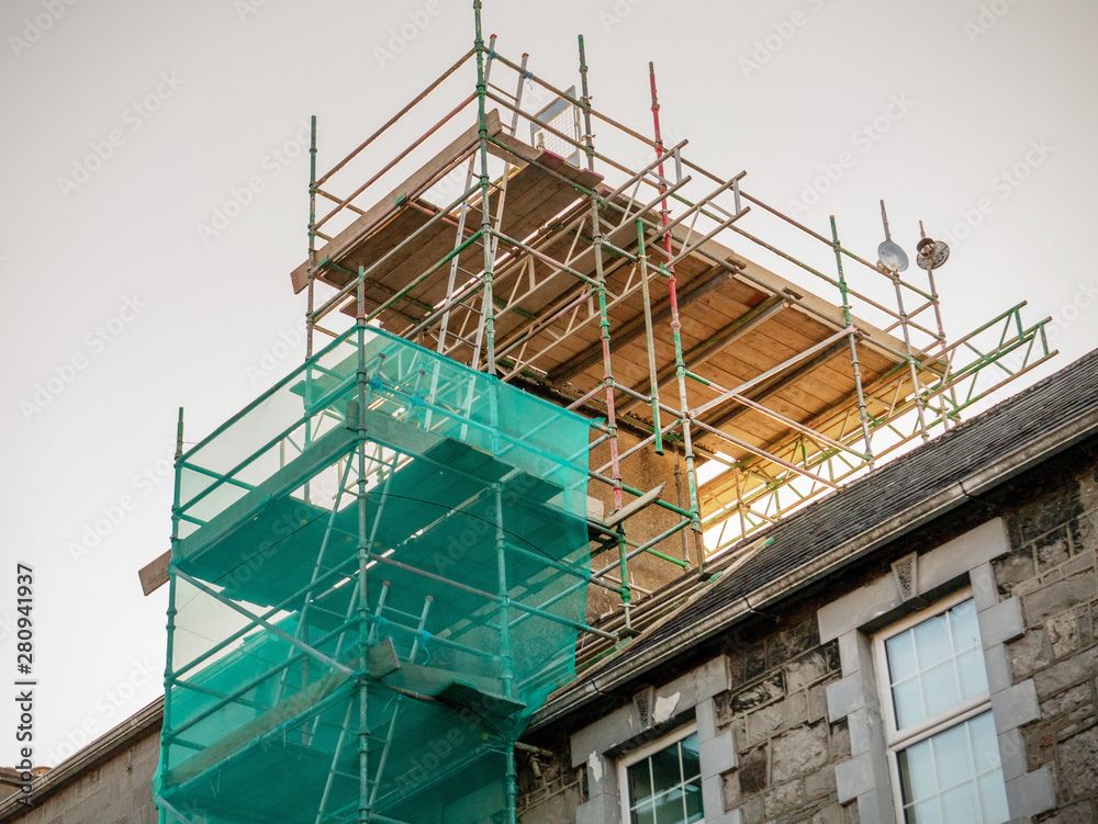 Scaffolding set on an old house to repair chimney. Construction business concept and technology.