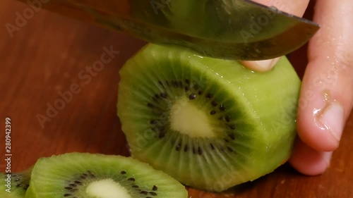 a girl cuts kiwi