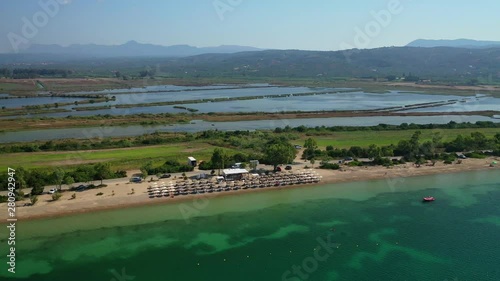 Aerial drone video of iconic secluded sandy beach with emerald sea in island of Sfaktiria next to bay and famous beach of Divari (chrysi akti), Messinia, Gialova, Peloponnese, Greece photo