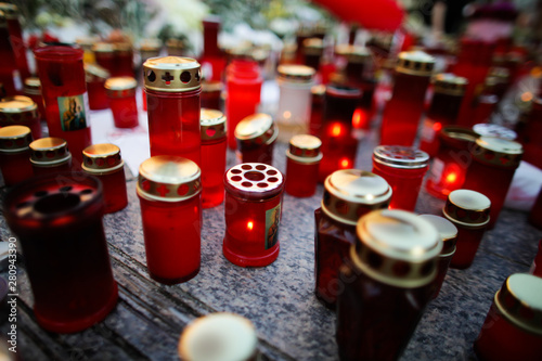 Shallow depth of field image with details of candles put on the pavement by people
