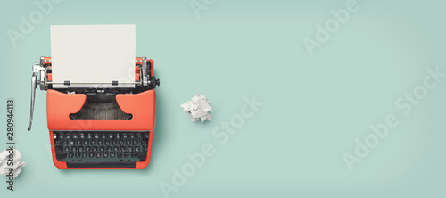 retro banner with red vintage typewriter with a blank sheet of paper and paper balls, top view, copyspace photo