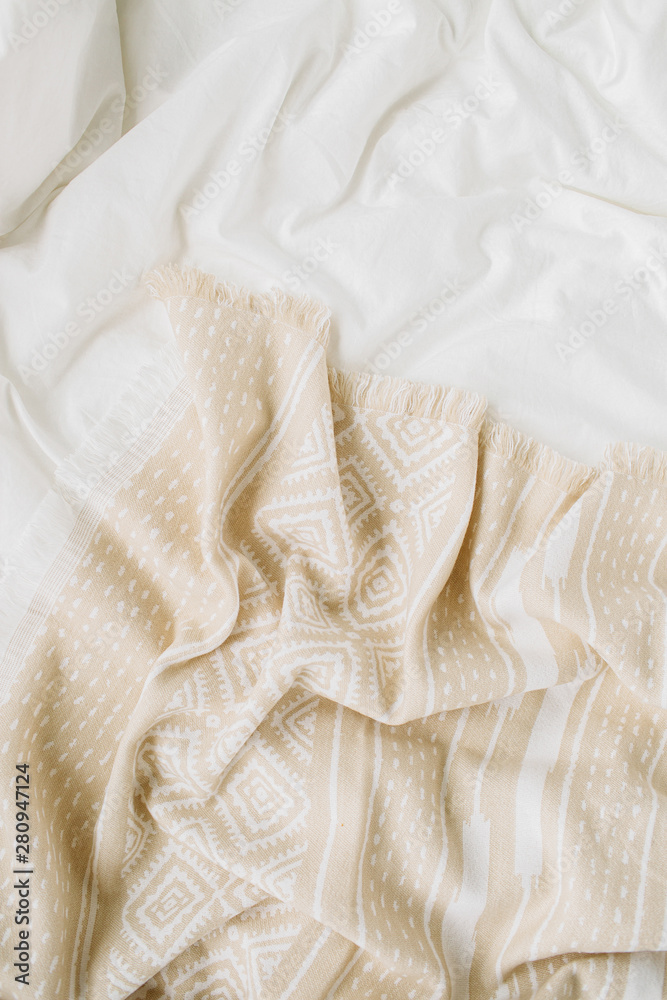 White bedding with warm plaid. Cozy background with copy space. Scandinavian style. Flat lay, top view White bedding with warm plaid. Cozy background with copy space. Scandinavian style. Flat lay, top view