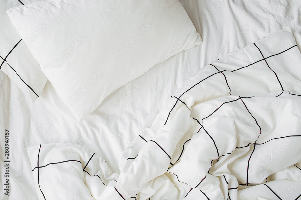 White bedding sheets with striped blanket and pillow. Messy bed. Cozy  background. Stock Photo | Adobe Stock