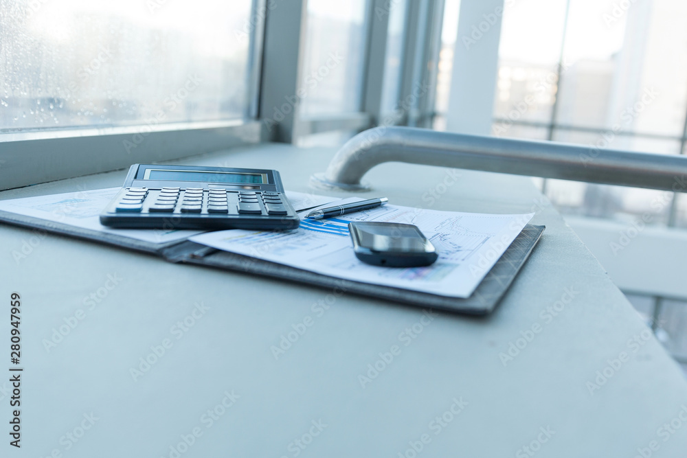 calculator, smartphone and financial documents on the businessm calculator, smartphone and financial documents on the businessm