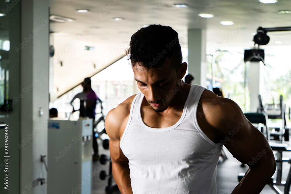 Fit man standing and relax after the training session in gym,Concept healthy and lifestyle,Male taking a break after exercise and workout
