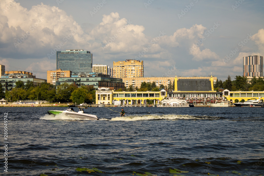 Moscow / Russia - July, 27, 2019: motor boat and man on water skiing on Khimki reservoir summer day