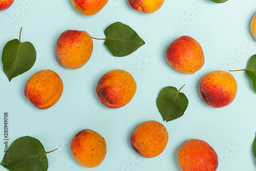 Apricots on a blue background  the flat lay image of ripe apricots and leaves 