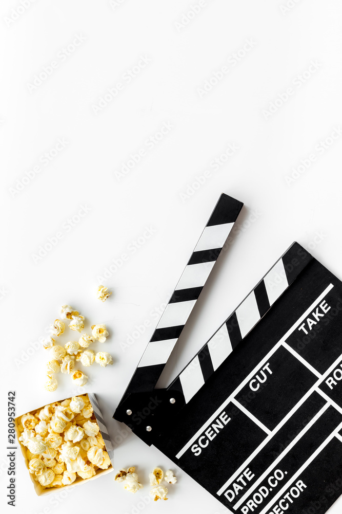 Filmmaker profession with clapperboard and popcorn on white background top view copyspace